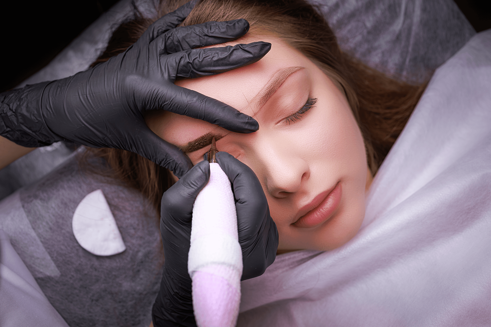 Permanent makeup artist performing a brow procedure